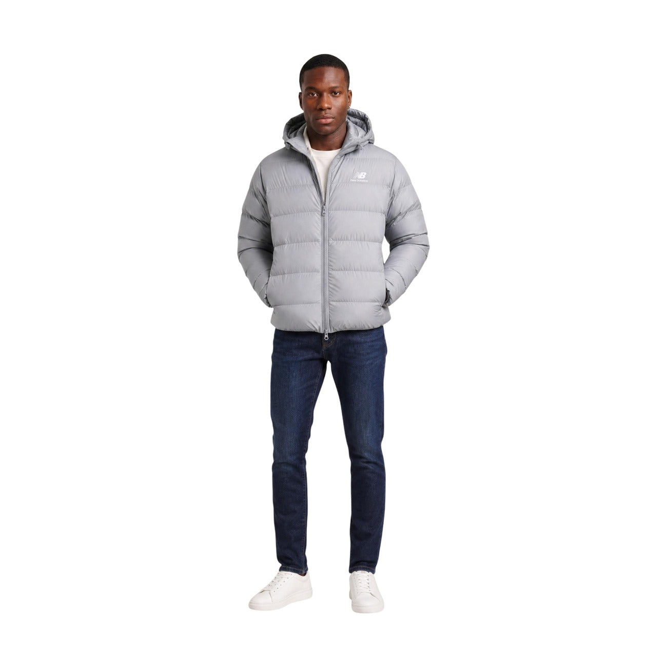 Piumino uomo New Balance grigio MJ62G17OYST. Giacca invernale pesante da uomo grigia con trapuntatura orizzontale, cappuccio, zip integrale, tasche con cerniera e logo ricamato, giubbotto casual sportivo da mezza stagione e freddo.