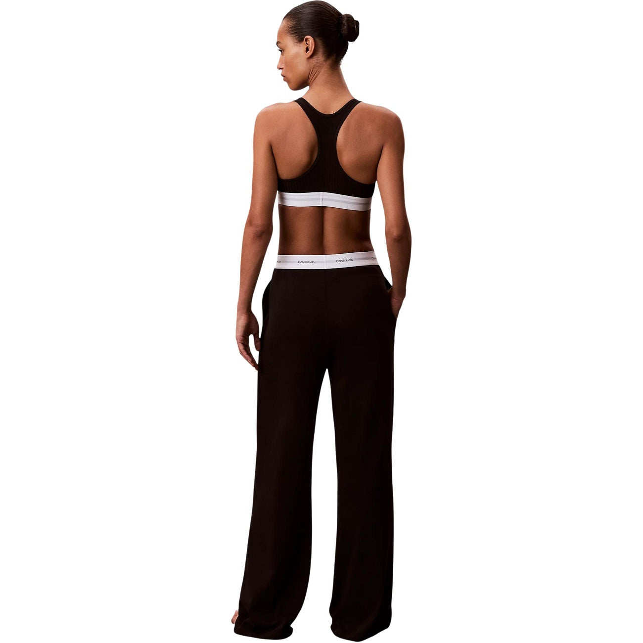 Pantaloni pigiama Calvin Klein donna neri modello LOGO JERSEY PANT. Pantalone lungo da notte e loungewear in maglia di cotone a coste tinta unita con tasche laterali e fondo con risvolto, dotato di fascia elastica logata in vita, stile casual sportivo e minimale.