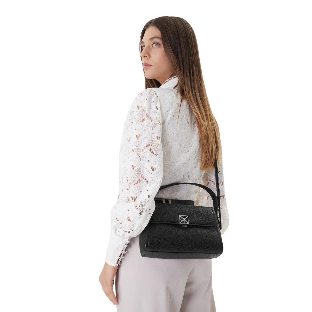 Borsa a spalla Calvin Klein in ecopelle martellata; chiusura magnetica, tasca interna, tracolla regolabile. Design compatto ed elegante. Colore nero vista frontale indossata da modella 