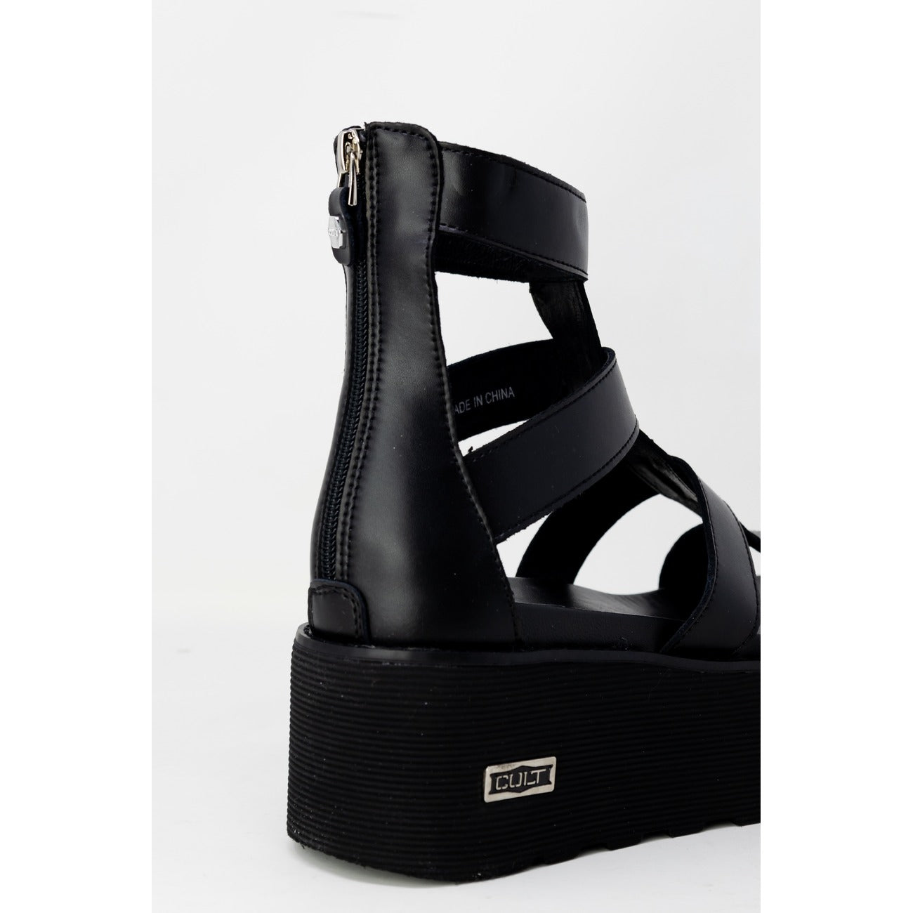 Sandali Platform Cult Nancy; Nero. Pelle e poliuretano, tacco 6 cm, suola dentellata. Chiusura con zip posteriore, logo metallico laterale. Stile grintoso e moderno. Posteriore 
