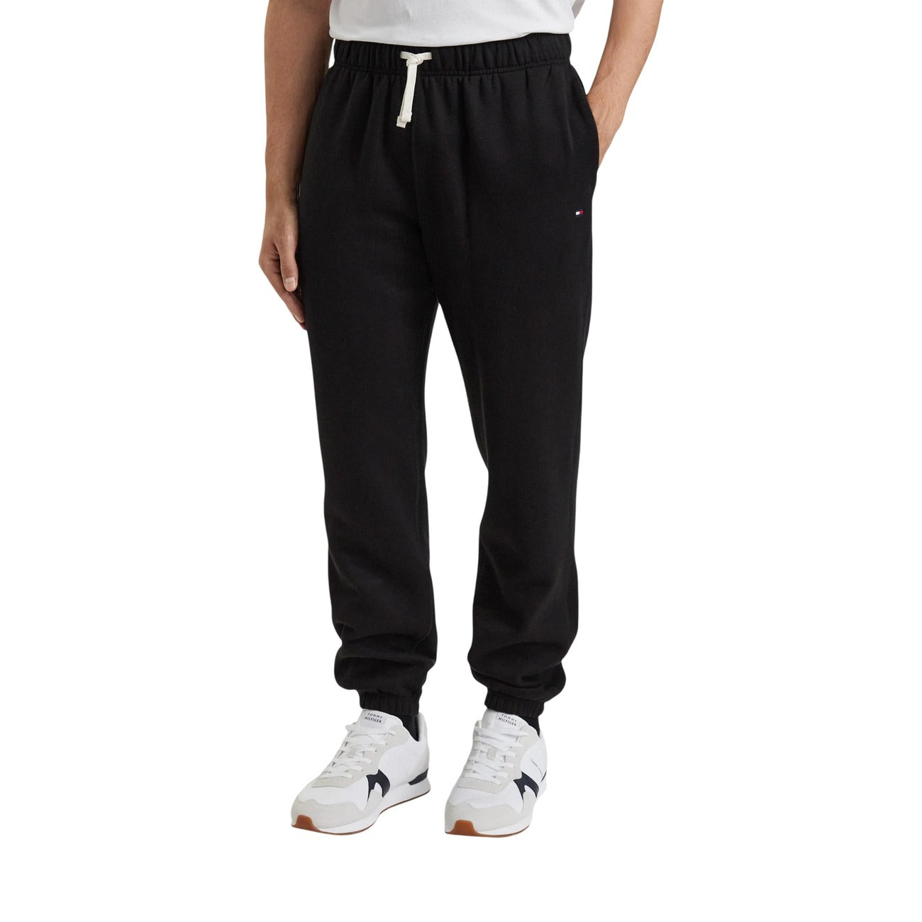 Pantaloni tuta Tommy Hilfiger Essential Fleece SWE nero uomo. Joggers sportivi in cotone felpato manopesca con coulisse a contrasto, fondo con elastico alle caviglie e logo ricamato, abbigliamento casual autunno inverno.