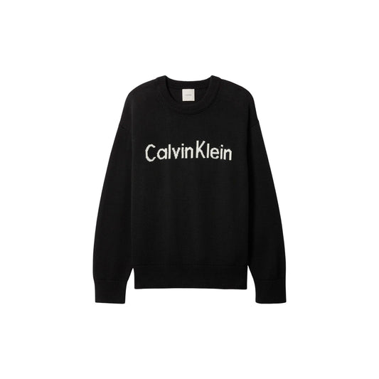 Maglione Girocollo Donna Nero Calvin Klein Jeans; Maglia in puro cotone con maxi logo frontale a contrasto. Silhouette regolare con spalle scese, polsini a costine e stile casual. Frontale stesa 