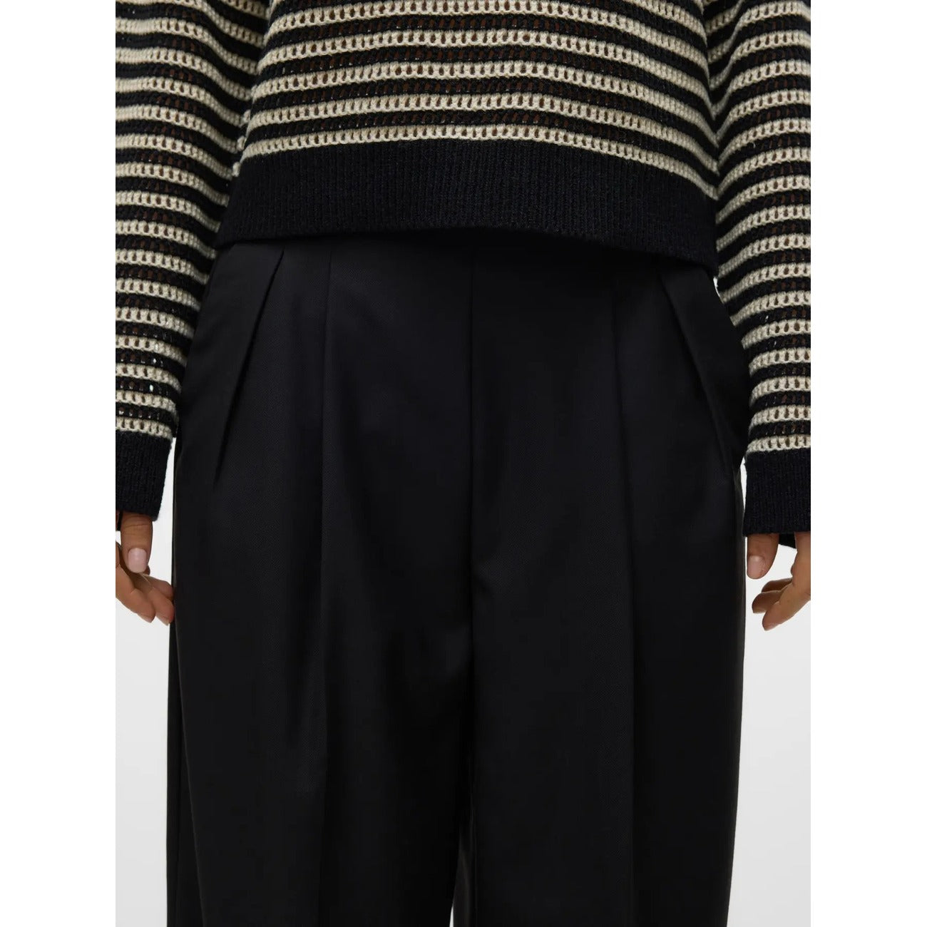 Pantaloni Donna Neri Vero Moda Wide Leg; Taglio a gamba larga in poliestere e viscosa fluida. Vita alta con pieghe frontali, chiusura con zip e tasche anteriori, stile casual-elegante continuativo.
