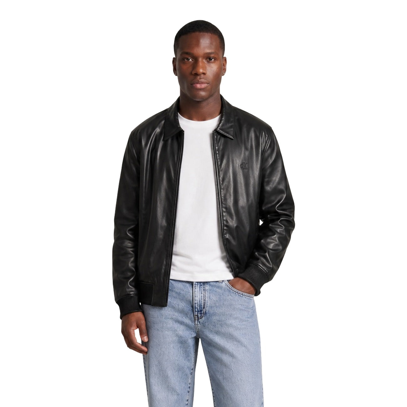 Giacca Leggera Nera Uomo Calvin Klein Jeans; Tessuto 100% poliestere riciclato con colletto classico e chiusura a zip. Polsini e fondo elastici con logo CK tono su tono sul petto, stile casual per mezza stagione. Vista frontale 