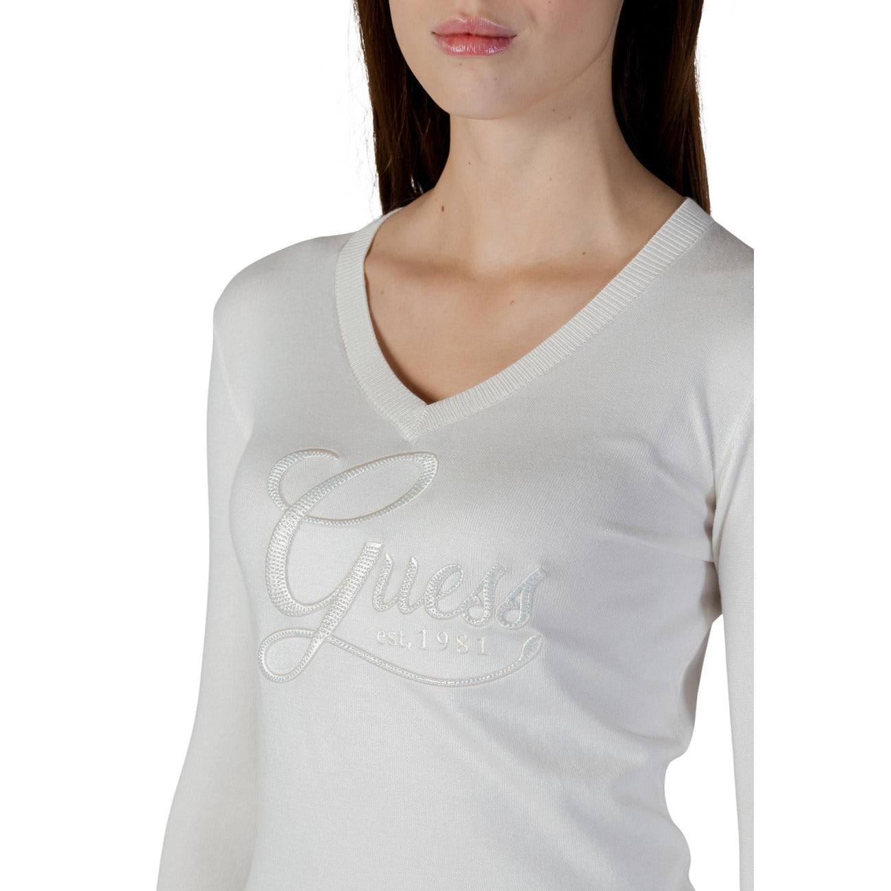 Maglia Guess Stephanie; Bianco. 82% Viscosa, 16% Poliammide, 2% Elastam. Scollo a V, logo gioiello, maniche lunghe. Tessuto fluido e aderente, stile chic quotidiano. Dettaglio 