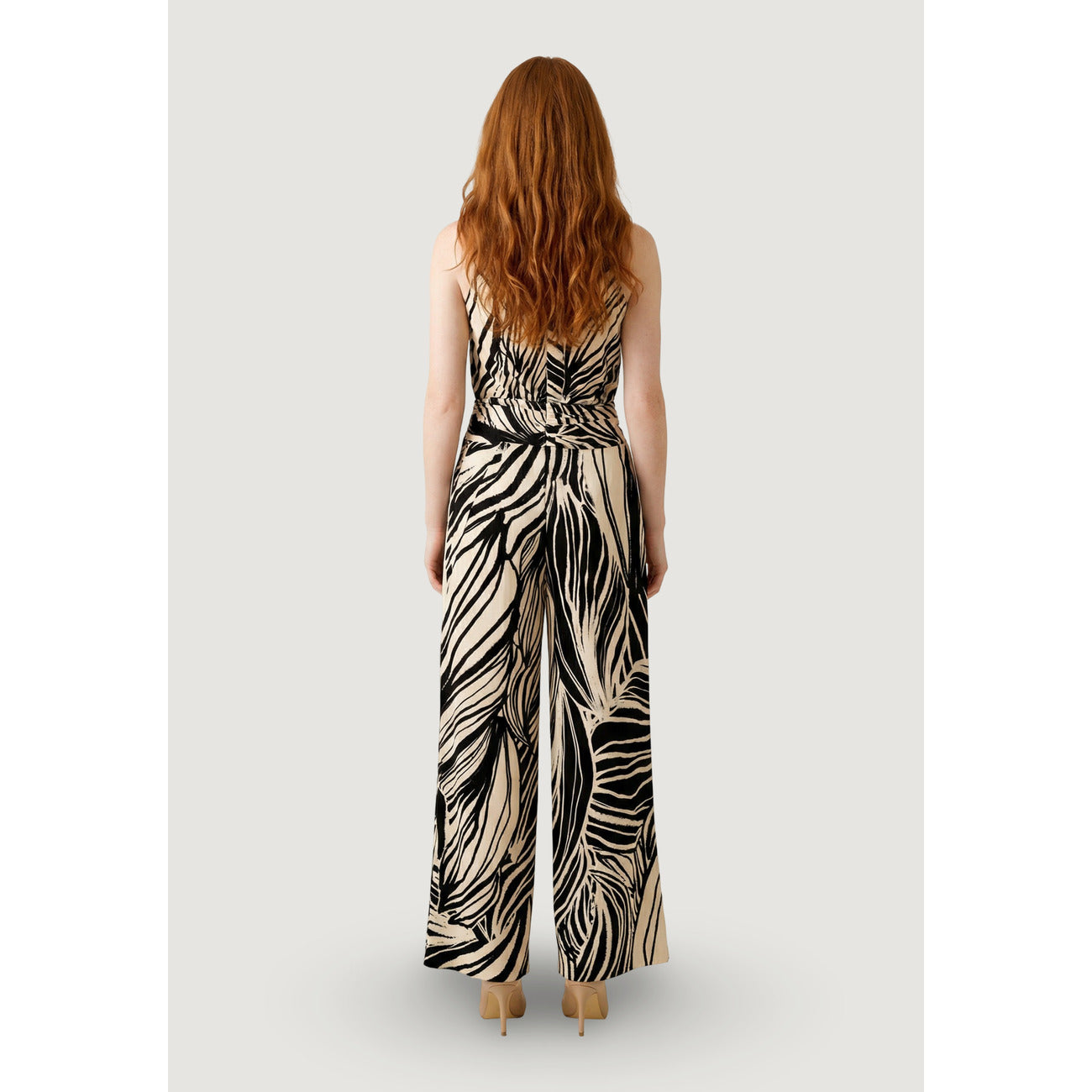 Guess Charline Jumpsuit; 88% Poliestere, 12% Elastam. Grafica dinamica, scollo alto, gamba larga. Tuta elegante donna elasticizzata e traspirante per la stagione PE26. Vista posteriore figura intera 